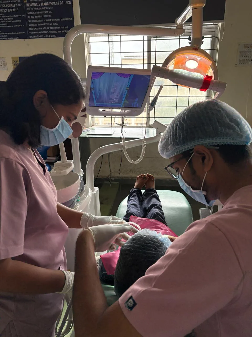 Dr. Kanani treating a child with his assistant at Orawell Dental Hospital Jamnagar